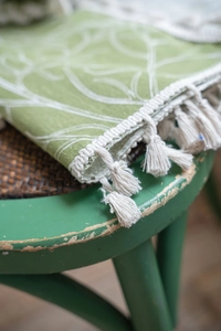 Detail shot of green leaf pattern fabric with high-quality white cotton fringe tassels