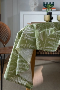 Detail of green tablecloth with white leaf pattern on textured cotton linen fabric