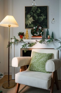 Detail shot of green festive pillow cover with leaf pattern on an armchair