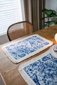 Dettaglio del tessuto jacquard con farfalla blu e nappe di cotone sul runner da tavolo