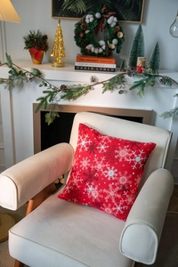 Detailed Christmas red pillow cover featuring white snowflake patterns on a sofa