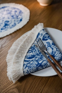 Dettaglio del runner da tavola jacquard blu e bianco con bordo di nappe decorative