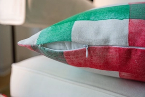 Detail showing the white hidden zipper and coarse woven fabric of the plaid Christmas pillow