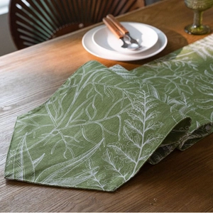 Runner da tavola verde con stampa di foglie in tessuto doppio su tavolo in legno
