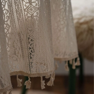 Beige crochet floral tablecloth with fringe tassels in a rustic farmhouse style
