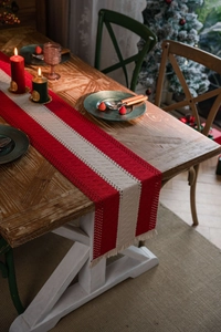 Festive red and white striped table runner with tassels and woven texture details