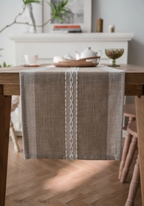 Close-up of modern geometric jacquard table runner with delicate white stitched patterns