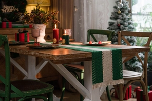 Detail of hand-woven cotton table runner with green stripes and decorative tassels