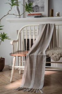 Close-up of geometric jacquard table runner with linen texture and elegant fringe detail