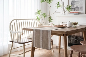 Close-up of Nordic woven texture and fringe detail on a light coffee cotton table runner