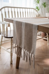 Detail of Nordic geometric table runner featuring handmade tassels and woven patterns