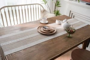 Close-up of beige table runner with Nordic jacquard texture and white lace trim