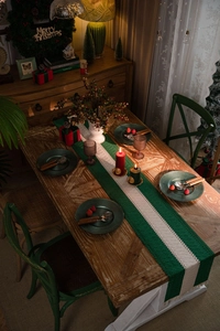 Detail of green and beige striped woven cotton table runner with festive holiday fringe