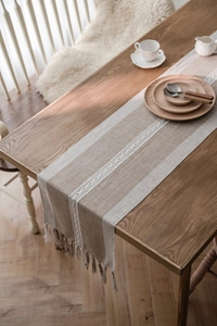 Detail of Nordic jacquard table runner with chain embroidery and woven tassels