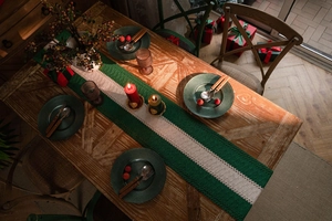 Close-up of crochet table runner with green and beige stripes for Christmas decor