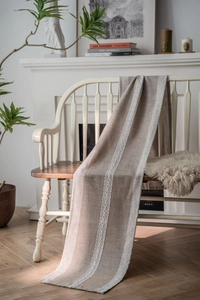 Close-up of Nordic woven table runner with braided pattern on a white wooden bench