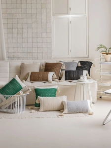 Detail of boho textured cushion covers with woven patterns and decorative tassels