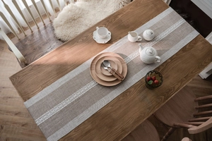 Macro detail of Nordic beige jacquard table runner with delicate white hollow crochet lace