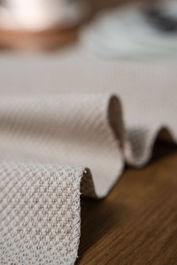 Macro shot of Nordic geometric jacquard table runner with heavy woven texture and fringe