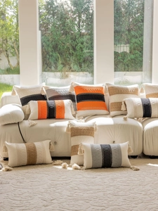 Detail of bohemian style woven pillow with textured stripes and fringe tassels