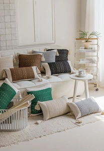 Close-up of bohemian style cushions with woven texture and decorative tassels