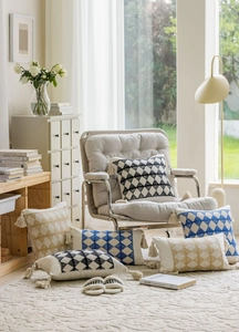 Detail of geometric rhombus pattern texture and fringe tassels on woven sofa cushions