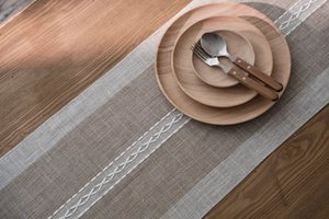 Close-up of Nordic geometric table runner with textured stitching and tassels