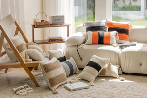 Detailed view of bohemian knitted cushion covers with stripes and tassels on a sofa