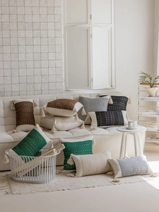 Detail of boho jacquard pillows with handmade crochet patterns and cotton tassels