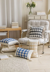Detailed view of geometric jacquard pillow covers with textured embroidery and tassels