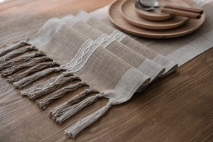 Detailed close-up of beige and brown geometric table runner with handmade fringe