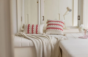 Detailed view of bohemian pillow cases with red heart embroidery and tassel accents
