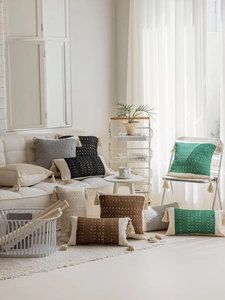 Close-up of Bohemian woven pillow covers with tassel edges and intricate crochet texture
