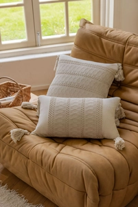 Detailed texture of bohemian beige cushion cover with crochet patterns and tassels