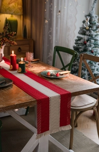 Close-up of red and beige striped cotton linen table runner with woven tassels and fringe