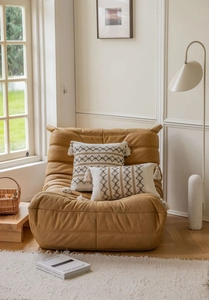 Close-up of bohemian style ivory pillow with black geometric embroidery and soft tassels
