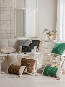 Detailed view of woven throw pillows with tassels in various colors and textures