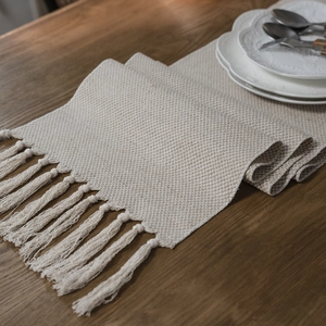Nordic jacquard geometric table runner with tassels on dark wood background