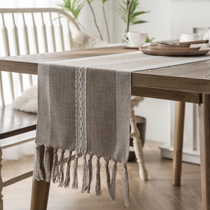 Nordic geometric jacquard table runner with tassels on a wooden dining table