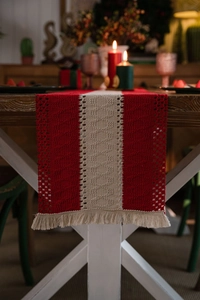 Detail of red and white striped table runner with woven diamond patterns and tassels