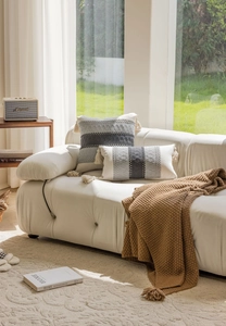 Detailed view of woven jacquard textures and handmade tassels on Nordic sofa pillows