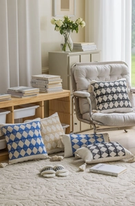 Macro detail of geometric jacquard patterns and handmade tassels on decorative cushions