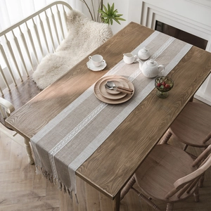 Boho geometric jacquard table runner with fringe tassel on a dark wooden table