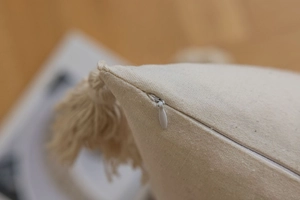 Close-up of the invisible zipper and beige cotton linen texture on a decorative cushion
