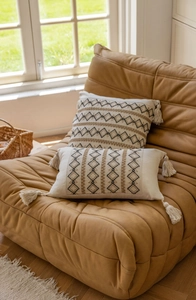 Detailed close-up of bohemian style jacquard throw pillow with geometric patterns and tassels