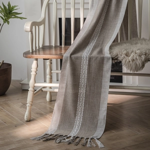 Nordic geometric jacquard table runner with tassels on a vintage white wooden bench