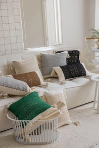 Detailed view of bohemian style knit throw pillows with fringes in diverse colors