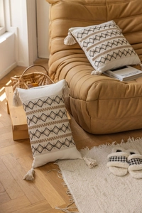 Close-up of Boho style pillow with diamond weave pattern and elegant beige tassels