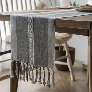 Nordic grey-blue woven table runner with white geometric embroidery and tassel fringe edges