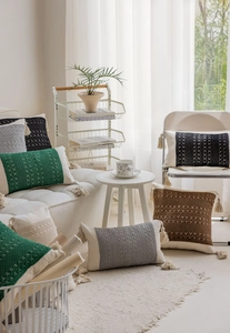 Close-up of Bohemian knitted pillowcases featuring textured patterns and elegant tassels